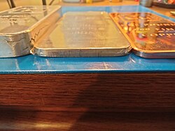 Three 1.0 pound (0.454 kg) bullion ingots of triple nine aluminium, iron, and copper etched with their scientific details.