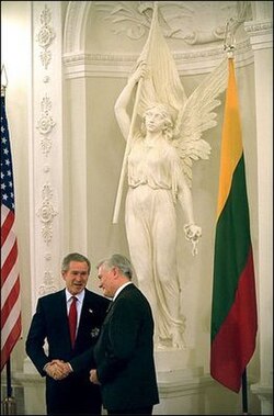 Adamkus shaking hands with George W. Bush in the Presidential Palace in Vilnius. In the background is a copy of a famous sculpture by Juozas Zikaras, the Statue of Liberty.