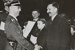 Heinrich Himmler handing naturalization papers to a repatriated Buconivian, Breslau, Germany (now Poland). c. 1941.