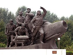 A monument in Pyongyang, depicting North Korean airmen and a MiG fighter