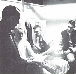 Bill Bowerman (left) conversing with Phil Knight (second from left) and two other members of the Oregon track team, 1958.