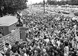 Fans gather outside Graceland to view Presley's body.