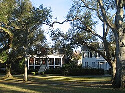 View of a part of Audubon Park with period-specific housing in the background.
