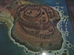 Model of a pā on a headland, showing the stepped nature and the wood palisades.