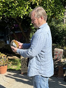 Karl Taube holding a piece of nephrite, one of two distinct mineral species called jade, 2023