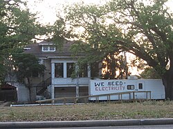 Trailer outside formerly flooded house in Broadmoor has complaint about no electricity painted on side; April 3, 2006