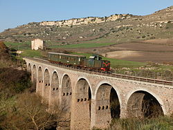 Tourist train in transit on a viaduct of the Sassari–Tempio–Palau railway in Italy