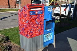 A Canada Post mailbox next to an empty Toronto Star vending box