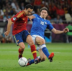 Xavi (left) turns away from Italy's Riccardo Montolivo in the Euro 2012 final.