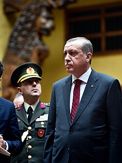 Erdoğan during an official visit to Peru, with a member of the Turkish army behind him