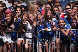 Young girls supporting the U.S. women's national soccer team at the ticker tape parade in New York City, celebrating their 2015 World Cup victory.