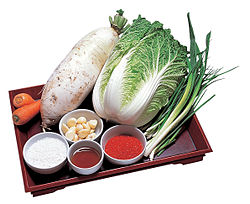 Basic ingredients for kimchi: napa cabbage, radish, carrot, salt, garlic, fish sauce, chili powder and scallions. A sticky, glutinous paste of rice flour is also needed to make the seasoning of the kimchi.
