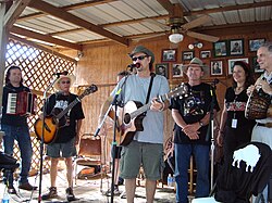 Jimmy LaFave performing at the Woody Guthrie Folk Festival with (L–R) Radoslav Lorković, Joel Rafael, Butch Hancock, Audrey Auld Mezera and David Amram, July 12, 2008