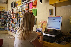 A woman sending an email at an internet cafe's public computer.