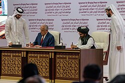US representative Zalmay Khalilzad (left) and Taliban representative Abdul Ghani Baradar (right) sign the Agreement for Bringing Peace to Afghanistan on 29 February 2020