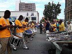 Band rehearsal on 125th Street in Harlem, the historic epicenter of African American culture. New York City is home by a significant margin to the world's largest Black population of any city outside Africa, at over 2.2 million. African immigration to New York City is now driving the growth of the city's Black population.[101]