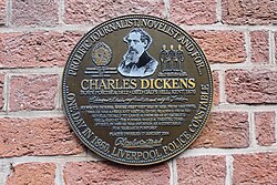Plaque in Campbell Square commemorating Charles Dickens who from 1842 gave public readings of his novels at St George's Hall, and who for one day in 1860 was appointed a special police constable in the city while researching a novel.