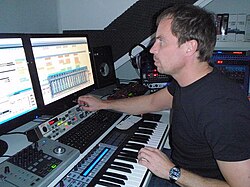 Music production in the 2000s using a digital audio workstation (DAW) with an electronic keyboard and a multi-monitor set-up
