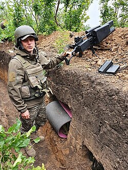 Ukrainian soldier inside a trench with a EDM4S portable anti-drone jammer