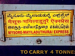 The name of a train found in South India written in four languages: Kannada, Hindi, Tamil, and English. Boards like this are common on trains that pass through two or more states where the languages spoken are different.