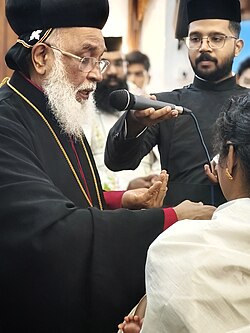 Metropolitan Thomas Mor Thimothios during the sacrament of baptism with the holy myron.