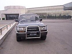Right-hand drive (RHD) Toyota Land Cruiser in front of a Pyongyang hotel