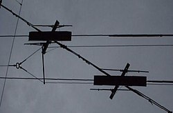 Tram overhead wire (diagonal) crossing trolleybus wires (horizontal), photographed in Bahnhofplatz, Bern, Switzerland