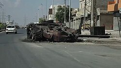A destroyed government tank on a road in Aleppo