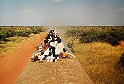 Passengers atop a train travelling towards Wau