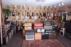 A range of guitar amplifiers and guitars for sale at a music store