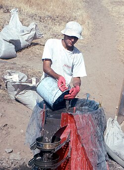 Flotation machine in use at Hallan Çemi, southeast Turkey, c. 1990. Note the two sieves catching charred seeds and charcoal, and the bags of archaeological sediment waiting for flotation.