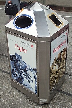 A three-sided bin at a railway station in Germany, intended to separate paper (left) and plastic wrappings (right) from other waste (back)