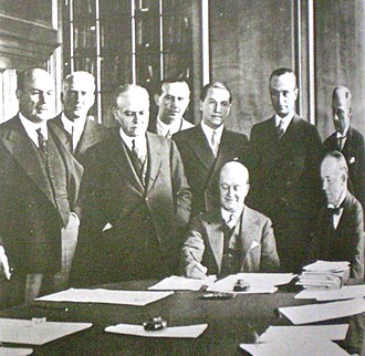 Argentine Vice President Julio Roca (jr.) signs the pact in the presence of British trade envoy Sir Walter Runciman (seated at right).