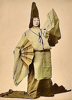 A miko (dressed for the Kagura dance), wearing a tall torikabuto headdress - after which the cowl-like flower of Aconitum carmichaelii is named in Japanese