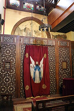 Side chapel in the Hanging Church in Old Cairo, including frescoes (partly visible behind the screen here) dating from the late 12th or 13th century, before the church's later renovation[212]