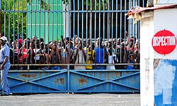 Haitians await the opening of a supply depot, 16 January.