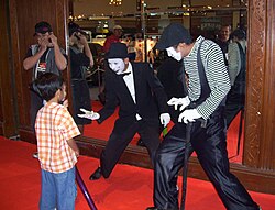 Two mime artists playing with children in Indonesia.