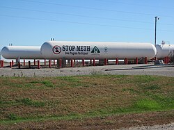 Anti-meth sign on tank of anhydrous ammonia, Otley, Iowa. Anhydrous ammonia is a common farm fertiliser that is also a critical ingredient in making methamphetamine. In 2005, Iowa used grant money to provide thousands of locks to prevent criminals from gaining access to the tanks.[132]