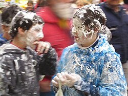 Children become covered in meringue during Dijous Gras, in Vilanova, Catalonia, Spain