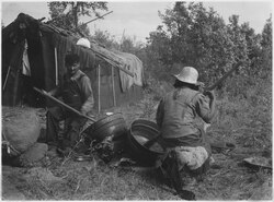 Vintage photo entitled, "Paul Buffalo and wife parching wild rice at their camp" – 1934