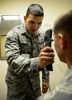A technician at Aviano Air Base Optometry Clinic measures the intraocular pressure of a patient with a handheld tonometer, July 7, 2015.