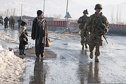 US Army Soldiers walk by local Afghan boys during a patrol in Gardez, 2012