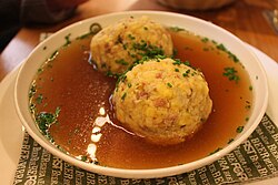 Traditional speck knödel soup. The cuisine of South Tyrol combines culinary influences from Italy and the Mediterranean with a strong alpine regional and Austrian influence.