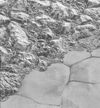 Solid nitrogen on the plains of Sputnik Planitia (on the bottom-right side of the image) on Pluto next to water ice mountains (on the up-left side of the image)