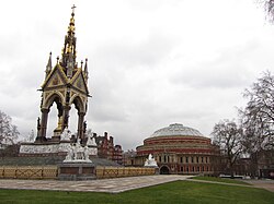 The Albert Memorial is located opposite the Royal Albert Hall, within the same area around Kensington Gardens.
