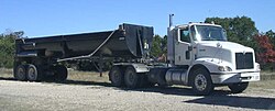 A rear dump trailer with a daycab tractor