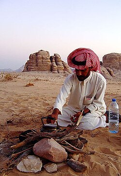 A young Bedouin lighting a camp fire in Wadi Rum, Jordan