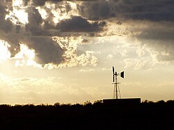 Sunset in the Great Karoo, near Sutherland, showing a multibladed windpump, which has made permanent settlement and farming possible in this thirsty land. These windpumps are as iconic of the Great Karoo as are the flat-topped Karoo Koppies.