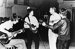 The Beatles working in the studio with their producer George Martin, c. 1965