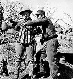 Chinese suicide bomber putting on an explosive vest made out of Model 24 hand grenades to use in an attack on Japanese tanks at the Battle of Taierzhuang
